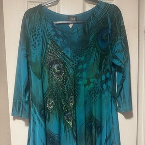 Jostar teal blouse. Embellished peacock feathers. Shark bite hem.